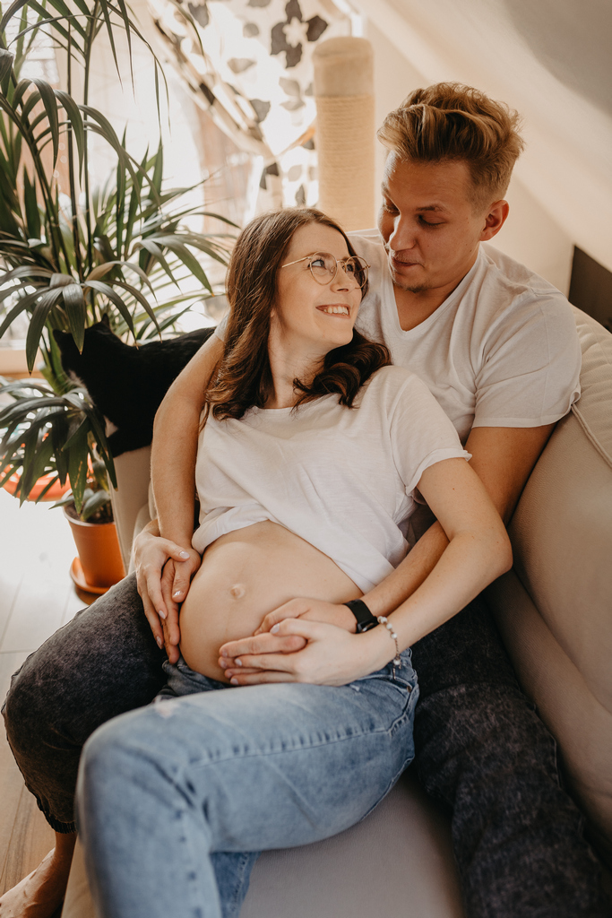 Przyszła mama na sesji brzuszkowej w domu, w Gdańsku, wraz z partnerem